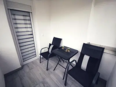 two chairs and a table in a room with a window at Apartman Luxe in Livno
