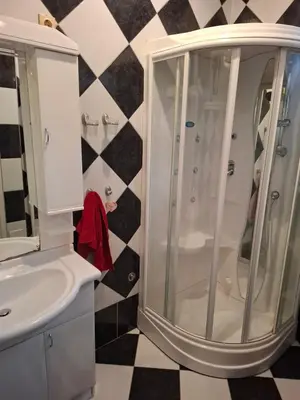 a shower in a bathroom with a black and white checkered floor at Mia lux centar in Banja Luka