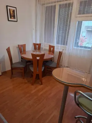 a dining room with a table and chairs and a window at Mia lux centar in Banja Luka