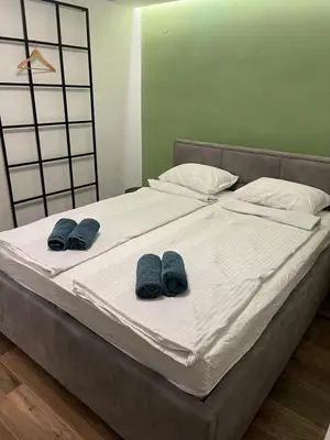 a bed with two pairs of blue slippers on it at Aleja bb apartment in Banja Luka