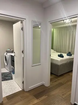 a bedroom with a bed and a door with a mirror at Aleja bb apartment in Banja Luka