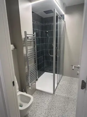 a bathroom with a toilet and a glass shower at Aleja bb apartment in Banja Luka