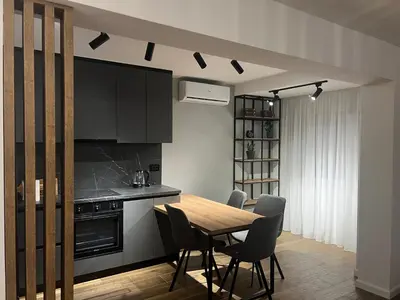 a kitchen with a wooden table and chairs at Aleja bb apartment in Banja Luka
