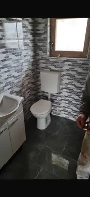a bathroom with a toilet and a sink and a window at Planinska kuca Gogo in Kupres