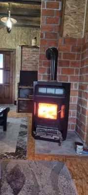 a fireplace in a living room with a brick wall at Planinska kuca Gogo in Kupres