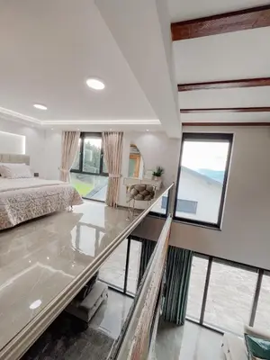 a bedroom with a large bed and large windows at Villa Bosanska Zvijezda in Vlasic