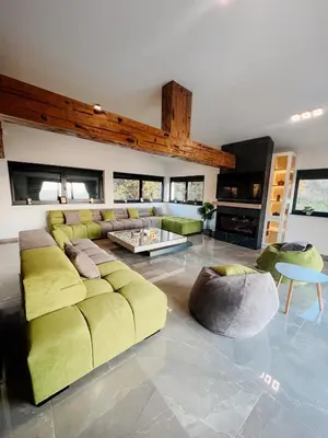 a living room with a yellow couch and a table at Villa Bosanska Zvijezda in Vlasic
