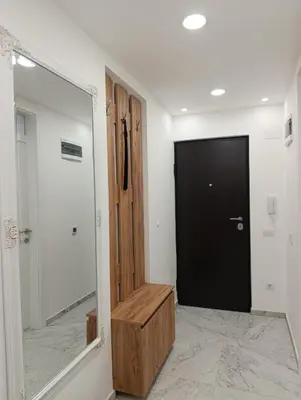 a hallway with a mirror and a black door at Bella Vacanza Apartment in Banja Luka
