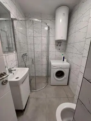 a bathroom with a shower and a washing machine at Index 1 in Hiseti
