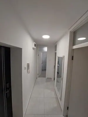 a hallway with white walls and a hallway with a mirror at Index 1 in Hiseti