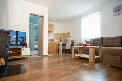 a living room with a couch and a table at Apartmani Biser Kupresa 1 in Kupres