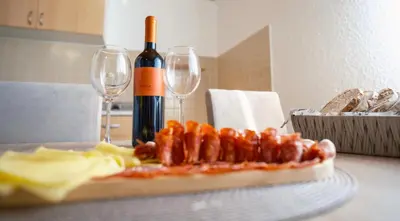 a table with a pizza and two glasses of wine at Apartmani Biser Kupresa 1 in Kupres