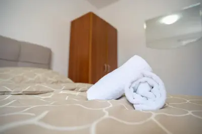 a pile of towels sitting on top of a bed at Apartmani Biser Kupresa 1 in Kupres