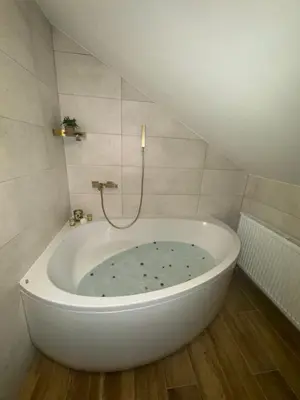 a white bath tub in a bathroom with a staircase at Country House Lištani-renta quad in Livno