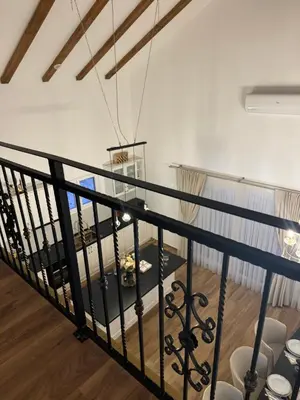 a staircase with a black rail and a table at Country House Lištani-renta quad in Livno