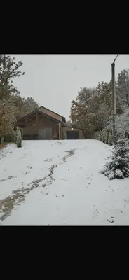 a snow covered yard in front of a house at Country House Lištani-renta quad in Livno