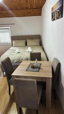 a bedroom with a bed and a table with a laptop at Apartman Biser Kupresa 3 in Kupres
