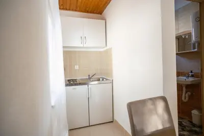 a small kitchen with a sink and a chair at Apartman Biser Kupresa 3 in Kupres