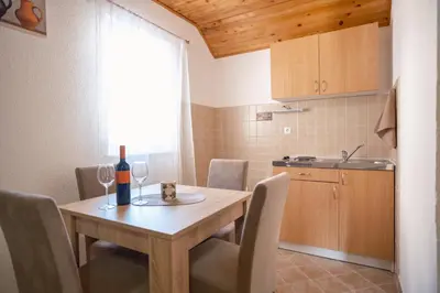 a kitchen with a table with a bottle of wine at Apartmani Biser Kupresa 4 in Kupres