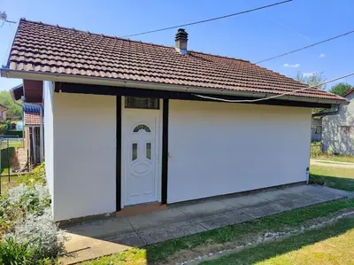 a small house with two white garage doors at Perfect Serene Escape in Kuljani