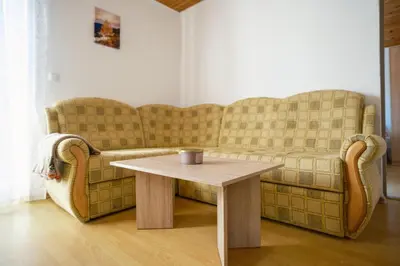 a living room with a couch and a table at Apartmani Biser Kupresa 5 in Kupres
