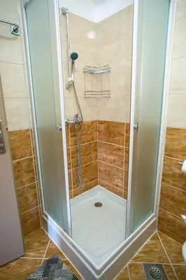 a shower with a glass door in a bathroom at Apartmani Biser Kupresa 5 in Kupres