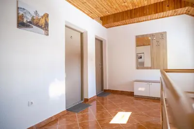 a room with white walls and a tile floor at Apartmani Biser Kupresa 5 in Kupres