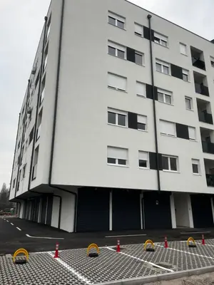 a large white building with orange cones in front of it at Apartman Sofija Banja Luka in Banja Luka