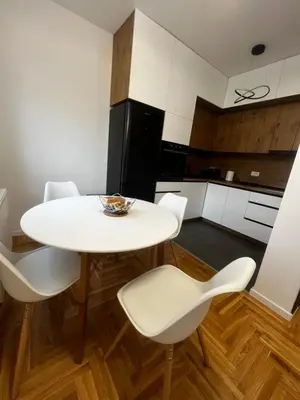 a kitchen with a white table and white chairs at Apartman Sofija Banja Luka in Banja Luka