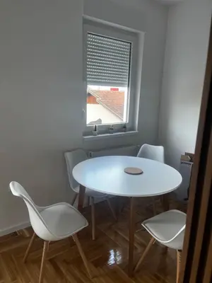 a white table and chairs in a room with a window at Apartman Sofija Banja Luka in Banja Luka