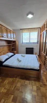 a bedroom with a large bed with blue sheets at Center Heritage Apartment in Teslić