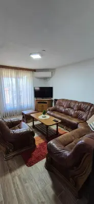 a living room with leather couches and a table at Center Heritage Apartment in Teslić