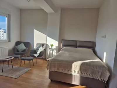 a bedroom with a large bed and two chairs at Apartman Sto in Banja Luka