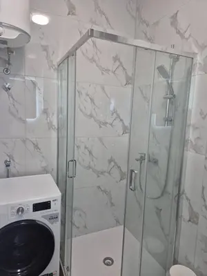 a shower in a bathroom with a washing machine at Apartman Sto in Banja Luka