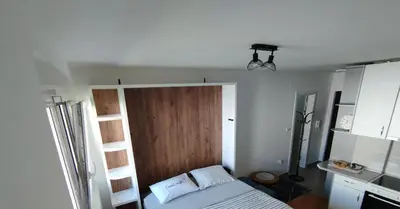 a small bedroom with a bed and a wooden door at Apartman Dunja Doboj in Doboj