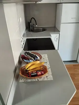 a kitchen counter with a sink and bananas on it at Apartman Dunja Doboj in Doboj