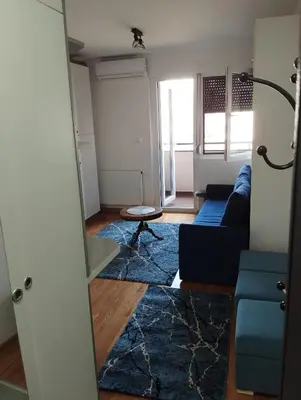 a living room with a blue couch and a blue rug at Apartman Dunja Doboj in Doboj
