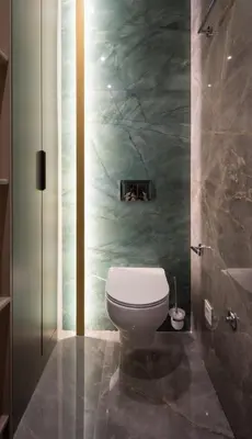 a bathroom with a toilet and a green wall at Luxury Apartments Palata - Stan Infinity in Banja Luka