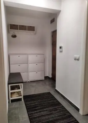 a kitchen with white cabinets and a stool in a room at Apartman Panić in Bosanska Gradiška
