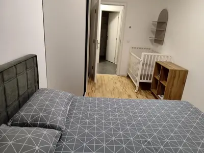 a bedroom with a bed and a hallway with a crib at Apartman Panić in Bosanska Gradiška