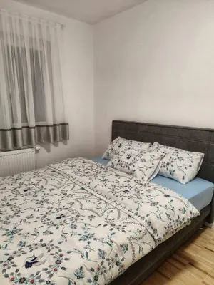 a bedroom with a bed with a blanket and pillows at Apartman Panić in Bosanska Gradiška