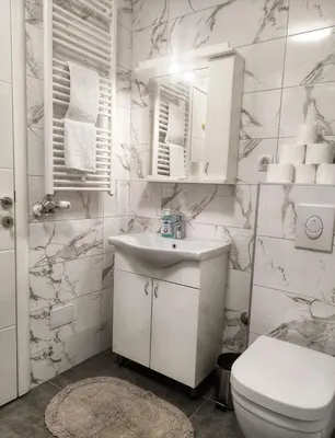 a white bathroom with a sink and a toilet at Apartman Panić in Bosanska Gradiška