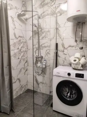 a washer and dryer in a bathroom with a stone wall at Apartman Panić in Bosanska Gradiška
