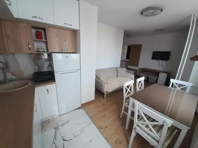 a kitchen and living room with a table and a refrigerator at stan san banjaluka in Banja Luka