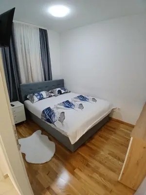 a bedroom with a bed and a wooden floor at Silencio in Banja Luka