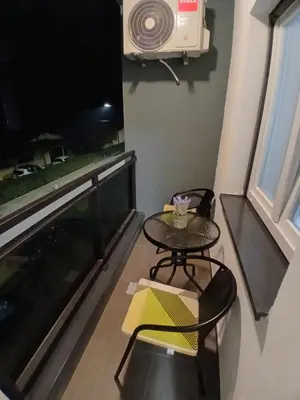 a small table and chairs in a room with a large window at Silencio in Banja Luka