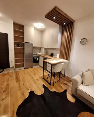 a kitchen and living room with a table and a couch at Stan na dan Trn Laktasi Apartman Andrea in Trn
