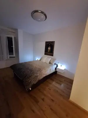 a bedroom with a bed with two lights on it at Stan na dan Trn Laktasi Apartman Andrea in Trn