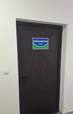 a brown door with a sign on it at Stan na dan Trn Laktasi Apartman Andrea in Trn