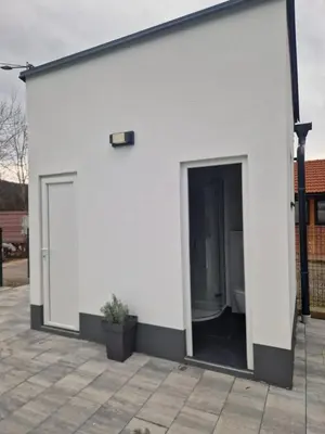 a white building with a door and a toilet at Kuća za odmor 